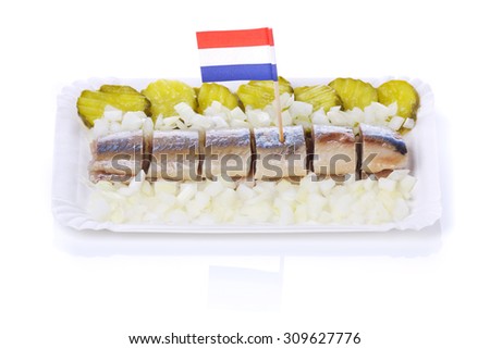 Dutch herring with gherkins and onions isolated on white. A traditional Dutch delicacy, with peak season at the end of spring when the first young herring is brought in from sea.