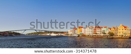 The waterfront in Willemstad, CuraÃ§ao in the Netherlands Antilles in late evening sunlight. With the coloured houses of Punda and the Queen Juliana Bridge in the background.