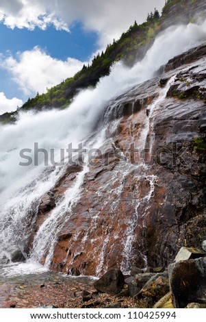 Roaring waterfall at the Mendenhall glacier in Juneau, Alaska.  Also known as Nugget Falls or Nugget Creek Falls