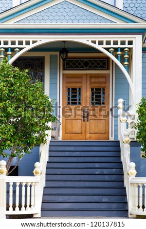 Front door of an old blue Victorian cottage in the San Francisco area