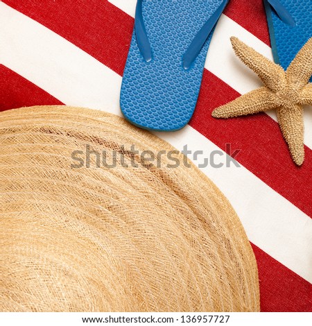 Flip flops, hat, towel, starfish for a day at the beach, pool or spa. Red, white and blue color theme, with square format.  Close up. Top view, looking down.