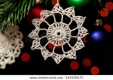 Christmas decorations hanging on the tree. White lacy crocheted stars. Close up detail.