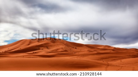 Sahara Desert sand dunes under gathering storm clouds. Copy space for text. Concepts: challenge, opportunity, silver lining, adventure