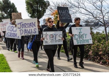 OAKLAND, CA-DEC 6,2014: Marchers protest recent Grand Jury decisions not to charge white police officers in the deaths of unarmed black men in Missouri and New York. Signs: \