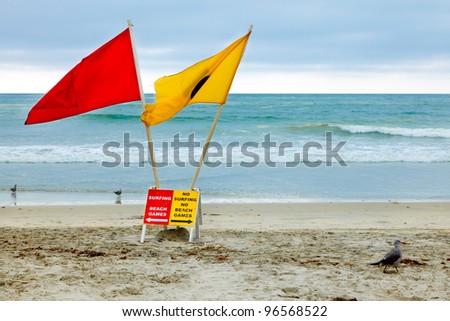Rules about surfing and beach games at a California Beach - colorful signs and flags