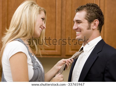 A woman fixing her husbands tie