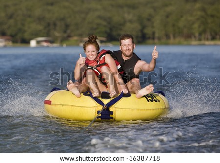 Thumbs up while tubing on a lake