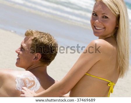 Woman Applying Lotion on a Man