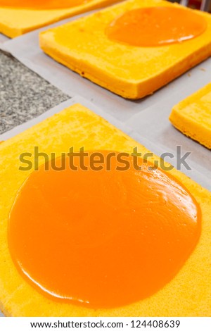 Cake with orange cream on top in making process