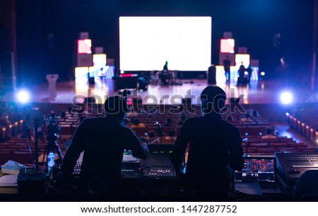 Blur image of sound engineer backstage crew team working to setting and preparing production for show events or music concert stage with blurry white screen in background.