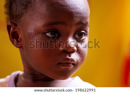 ACCRA, GHANA - MARCH 18: Unidentified young African boy with bright eyes look at far point on March 18, 2014 in Teshie community, Accra, Ghana. Ghana is one of the most tourists destination in Africa.