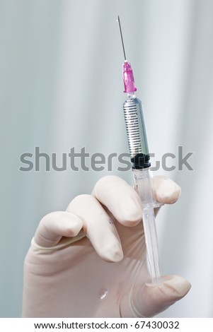 Doctor testing medicine syringe
