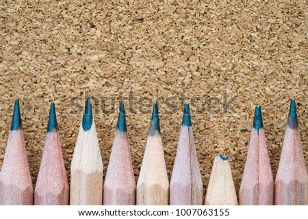 broken pencil tip beside of other sharp ones on particle board texture background with copy space, weakness point and teamwork failure concept 商業照片 © 