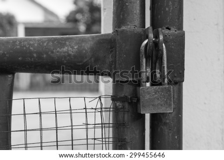 locked rusty silver padlock on house gate