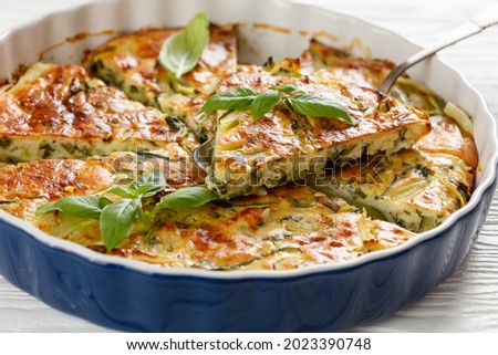 Scarpaccia salata, tuscan zucchini savory tart cut in slices in a baking dish on a white wooden table table, italian cuisine, close-up Stok fotoğraf © 