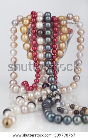 Beads from pearls in a wine glass for martini isolated on a white background