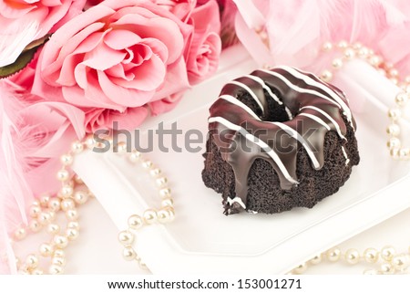Delicious chocolate cake with chocolate icing and white chocolate drizzle with pearls and pink roses