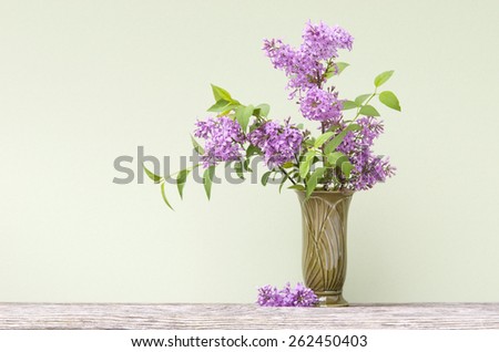 A spring bouquet of fresh cut fragrant purple lilacs in a vase with focus on lilacs, plenty of space for text