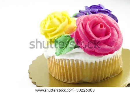 A vanilla cupcake with three colored frosting roses, white background with copy space, great for 
Easter or Birthday