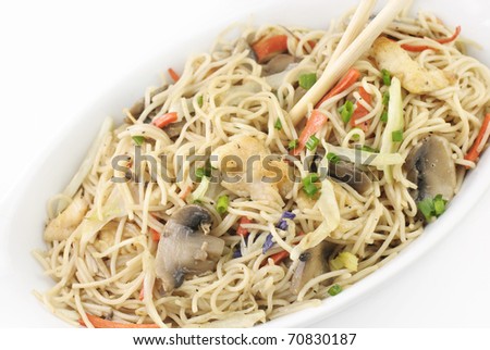 Chinese chicken and vegetable stir-fry with rice noodles, chicken, mushrooms, cabbage, carrots, with chopsticks, top view