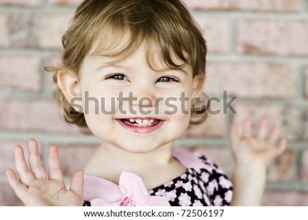 An adorable little girl with very expressive happy face, selective focus on face with blurred background