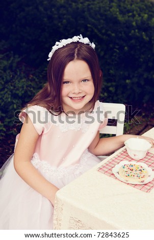 A beautiful little girl having a tea party