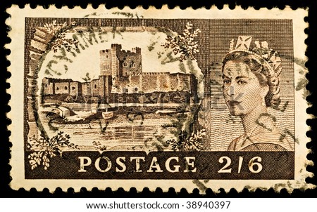 BRITAIN - CIRCA 1967: An old British stamp showing Carrickfergus Castle and portrait of Queen Elizabeth II, circa 1967