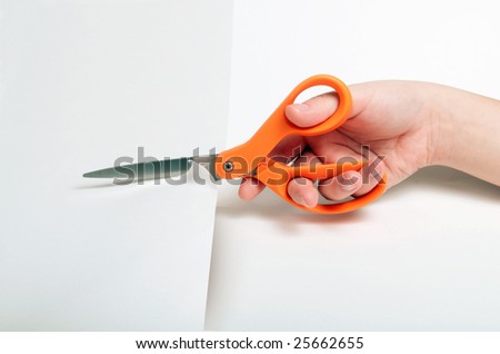 Orange handled scissors cutting through white paper