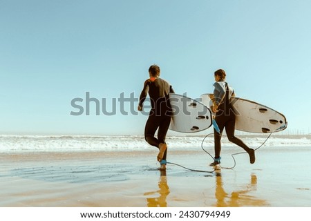 Similar – Image, Stock Photo Surfer entering into the water with his surfboard.