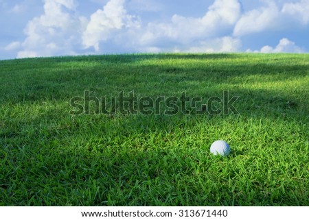 Golf ball on grass with blue sky