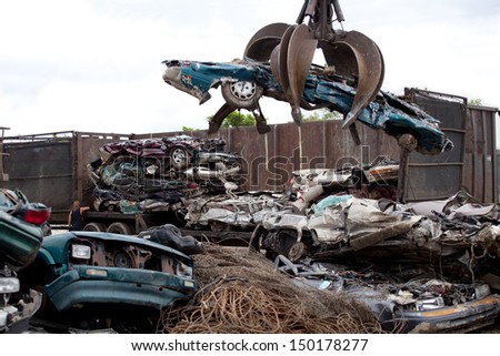 Crushed cars being picked up by a grabber