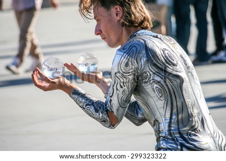 LONDON, UK - JUNE 30 2014 : Busker showing magic trick with crystal ball in front of National Gallery