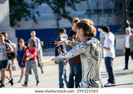 LONDON, UK - JUNE 30 2014 : Busker showing magic trick with crystal ball in front of National Gallery