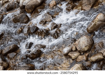 Similar – Foto Bild Schneller Wasserfall, der unter dem Sternenhimmel in der Abenddämmerung durch Felsen fließt