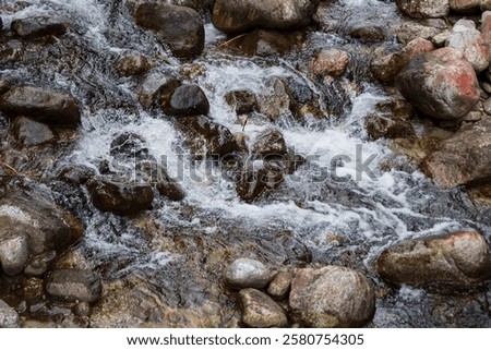 Similar – Foto Bild Schneller Wasserfall, der unter dem Sternenhimmel in der Abenddämmerung durch Felsen fließt