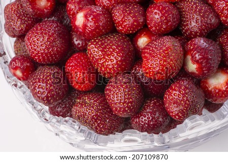 Ripe strawberries in a crystal bowl. Fragment from the top.