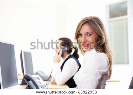 Young woman on the workplace at office works at the computer
