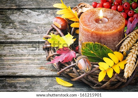 Autumn wreath with candle on wooden background