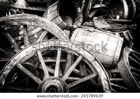 Old wooden barrels and broken wheels in retro setting