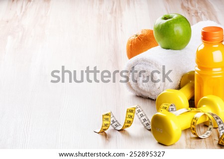 Fitness concept with dumbbells and fresh fruits