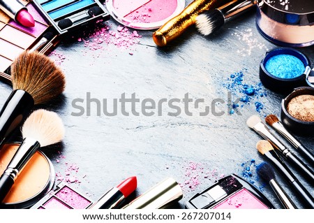 Colorful frame with various makeup products on dark background