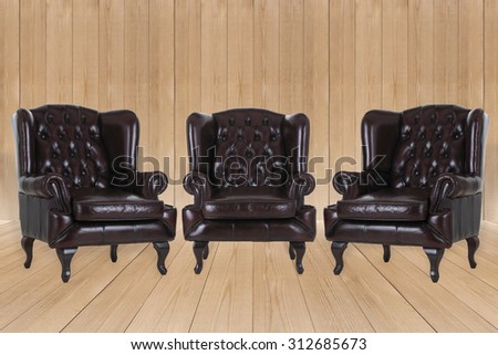 Vintage leather armchair on wood texture background