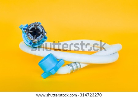 Rubber hoses for the water to the washing machine on a yellow background.
