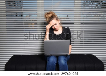 Creative young woman in apartment  with laptop puzzled look