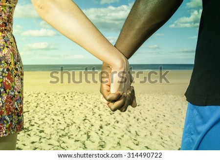 Multicultural  young  couple  hands holding  at beach sun sand and blue sky unity Instagram