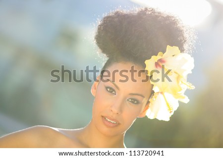 Portrait of a young black woman, model of fashion, with big flowers in her hair