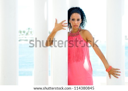 Portrait of a young black woman, model of fashion, with pink dress and earrings. Afro hairstyle