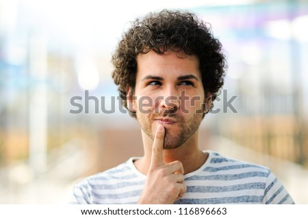 Portrait of handsome man with curly hairstyle in urban background