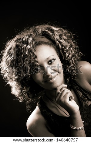 Portrait of beautiful black woman on black background. Studio shot
