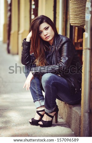 Portrait of beautiful japanese woman in urban background wearing leather jacket